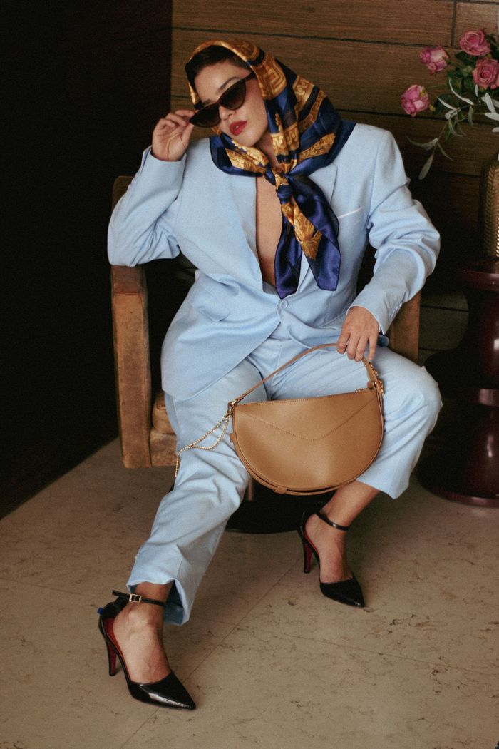 Fashion portrait of a stylish woman in a blue suit and headscarf, indoors.
