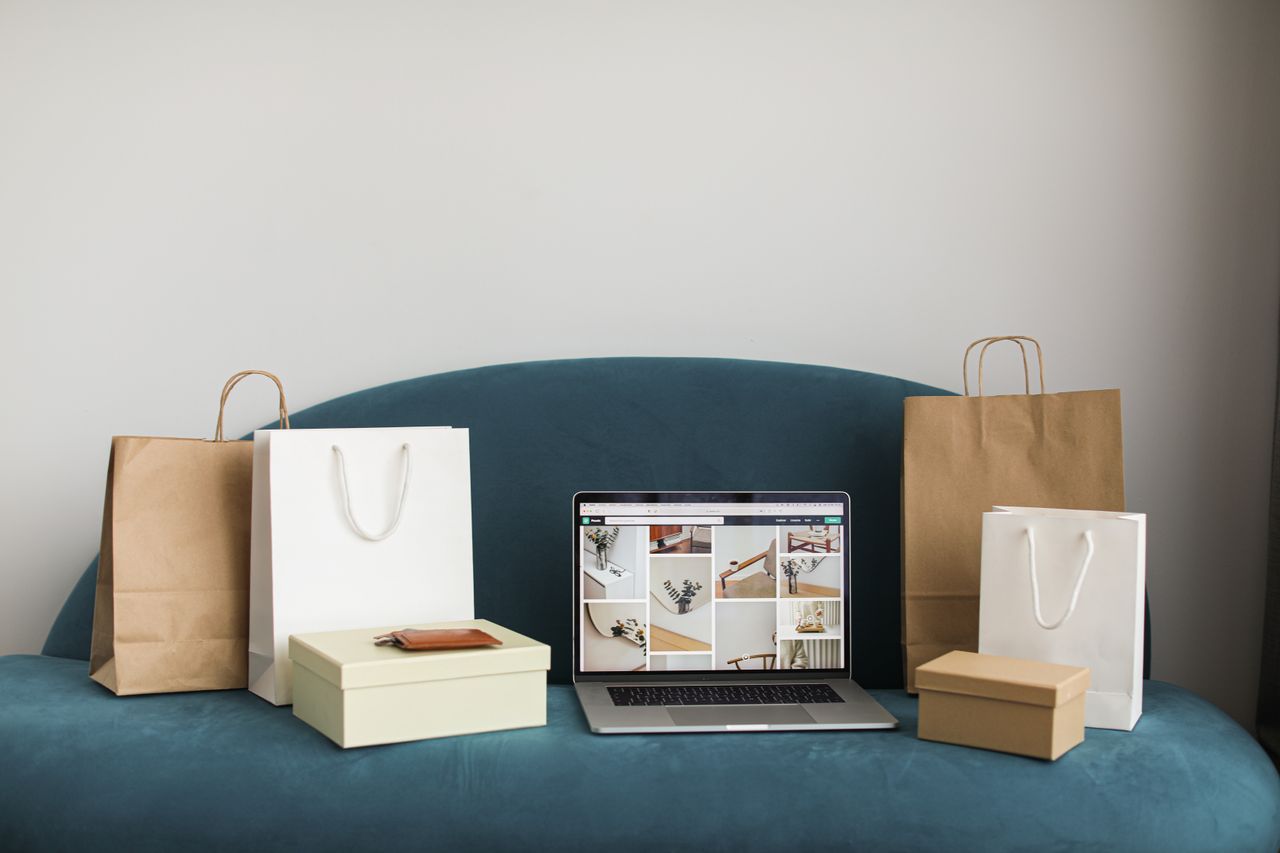 Crafting Captivating Headlines: Your awesome post title goes here A laptop surrounded by shopping bags and boxes on a blue sofa, ideal for online shopping themes.